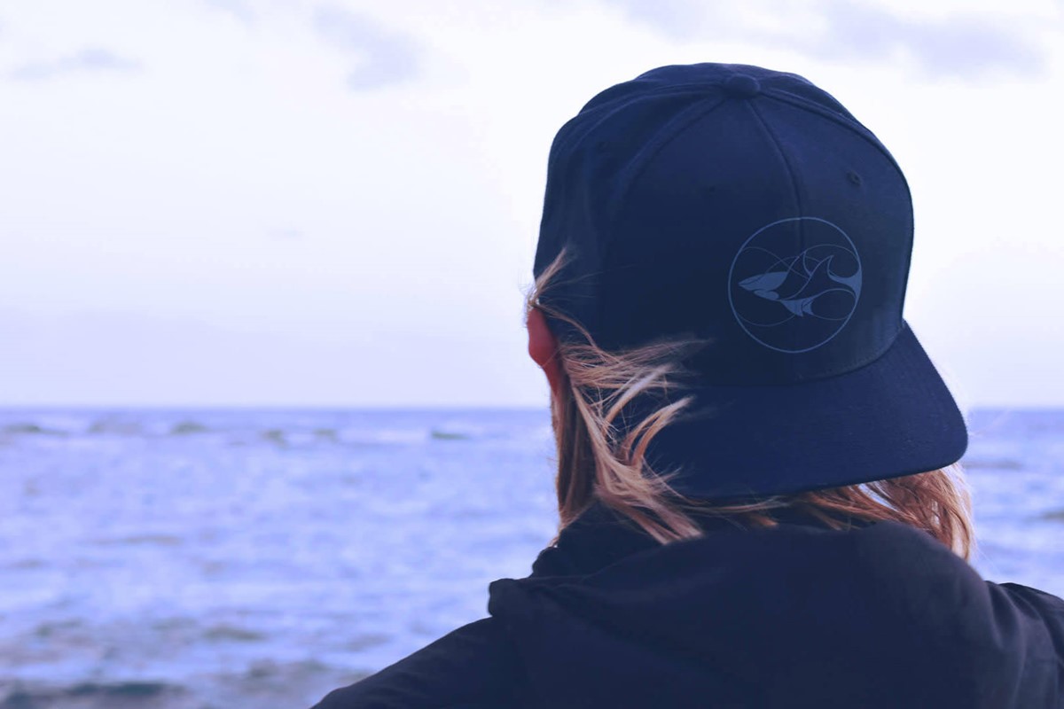 Shark Conservation Fund logo on a baseball cap mock-up. Wearer is looking out to sea.. Client: DiCaprio Foundation.