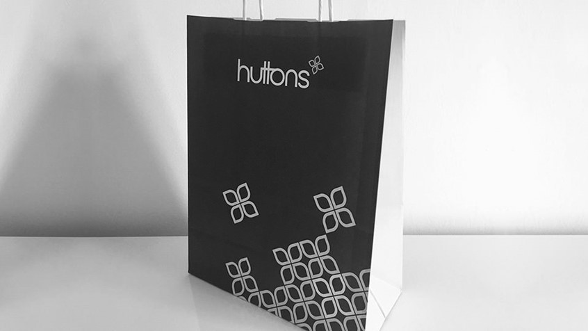 Huttons. Retail brand identity on a paper shopping bag - thumbnail. Design by Superfried.