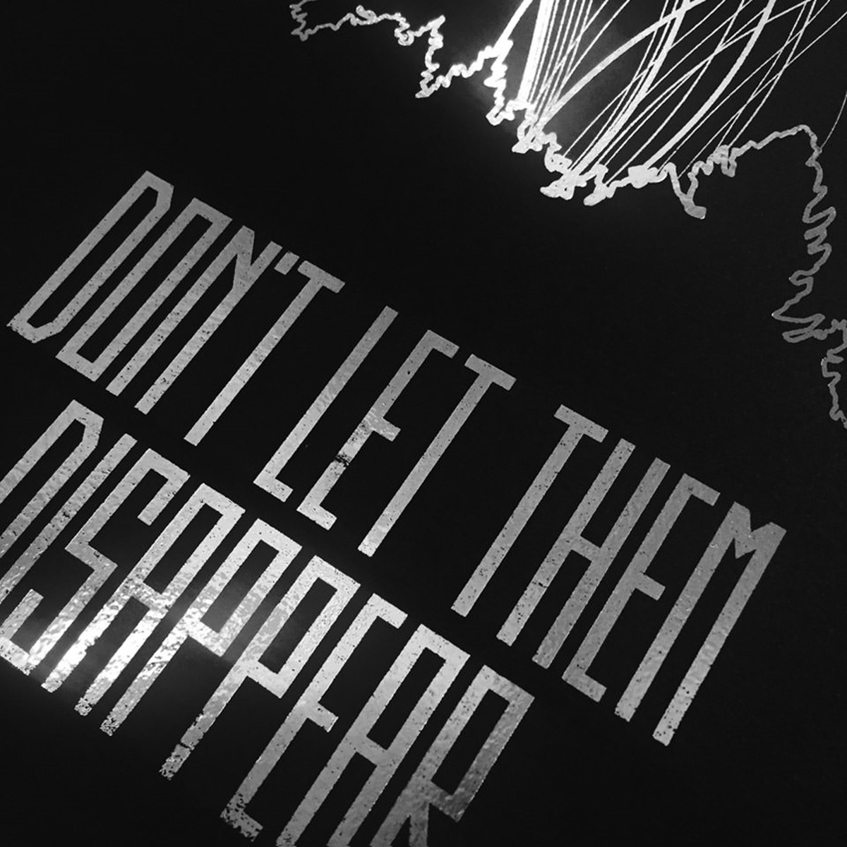 Detail close-up of foil poster featuring logo for Don't Let Them Disappear campaign. Client: Jane Goodall Institute and DiCaprio Foundation.