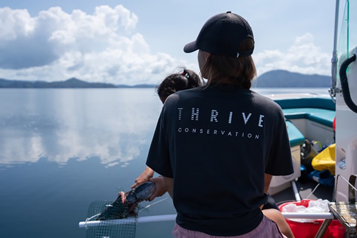 Thrive Conservation team member wearing branded t-shirt. Brand identity design by Superfried.